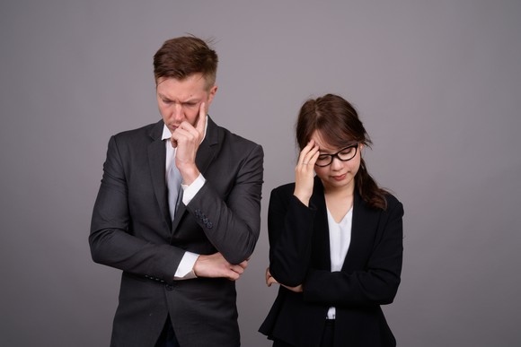Professionals in suits looking stressed