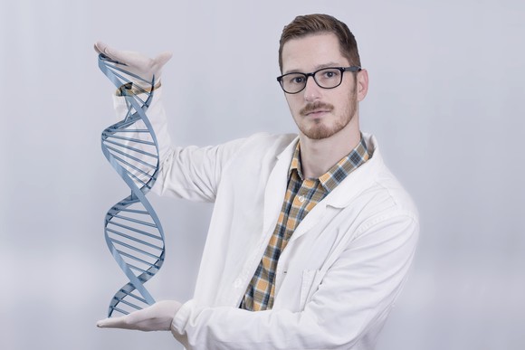 A biotech lab researcher holding a virtual DNA double helix.