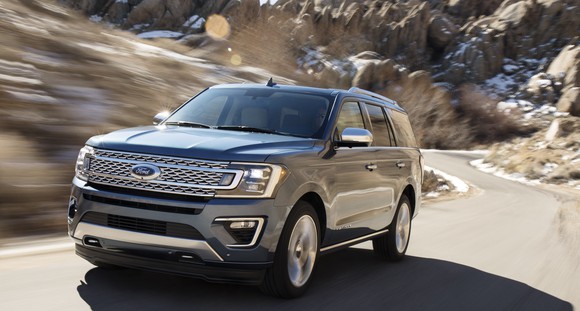 A 2018 Ford Expedition SUV in gray, on a winding mountain road.
