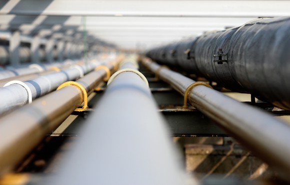 A head-on view of oil pipelines disappearing into the distance.
