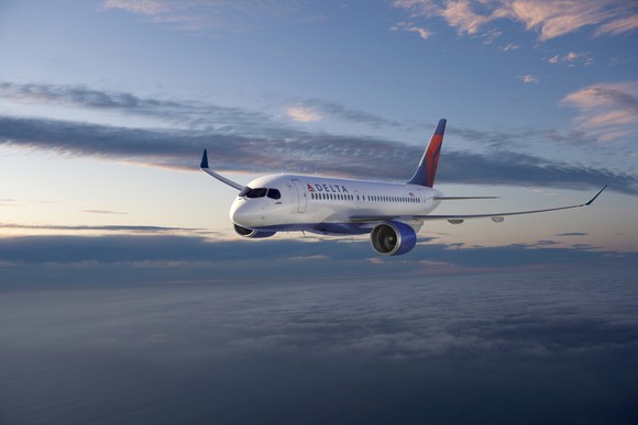 A Delta Air Lines plane in the sky among the clouds.