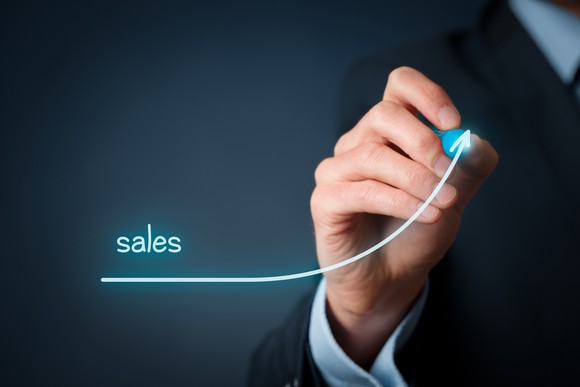 A businessperson drawing a line labeled "sales" that is curving sharply higher