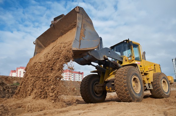 Front loader dumping a pile of sand