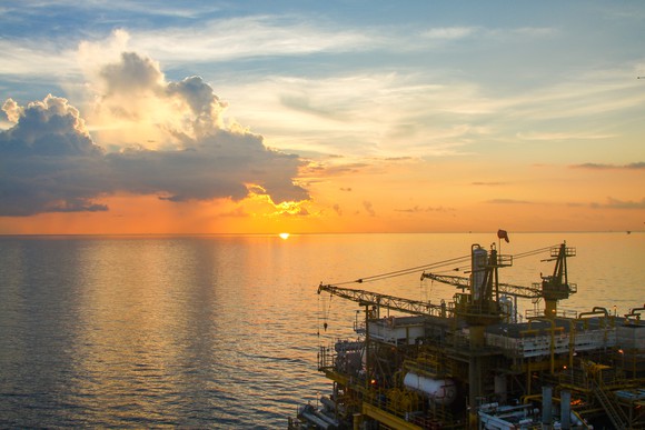 Offshore oil production platform at sunset