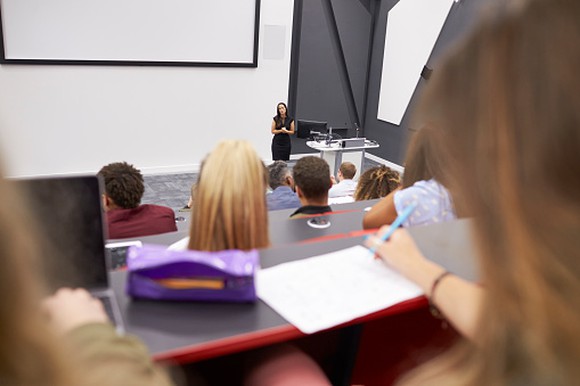 Woman lecturing in a classroom setting.