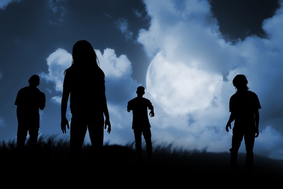 Zombies walking on a hill in the moonlight.