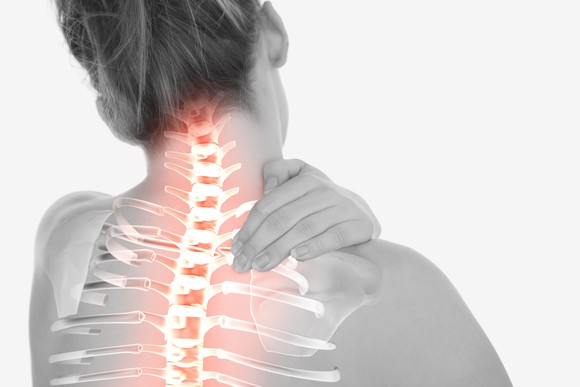 Highlighted spinal cord on woman facing away with hand on her shoulder