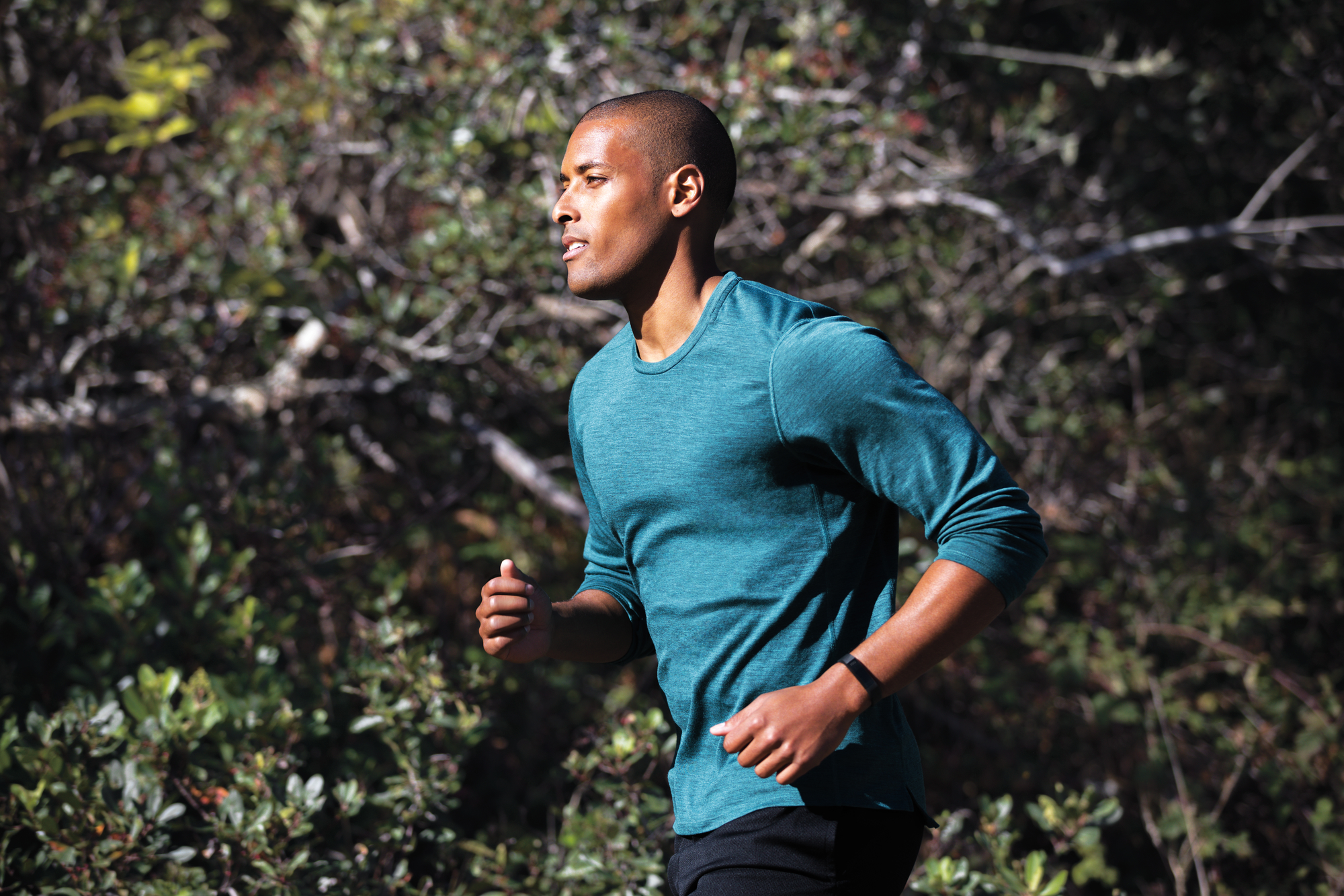 A man jogging, wearing a Fitbit Alta HR.