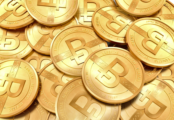 Pile of golden coins embossed with the Bitcoin logo.