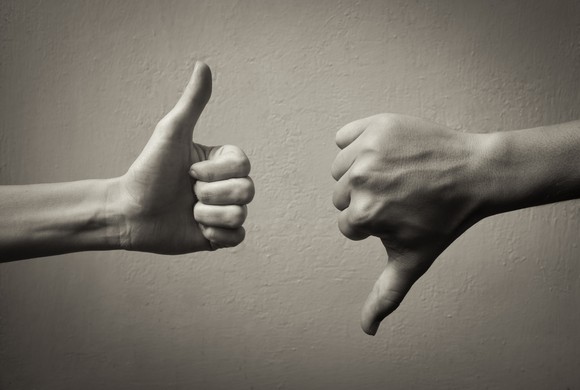 two hands in black and white, one thumb up and one thumb down