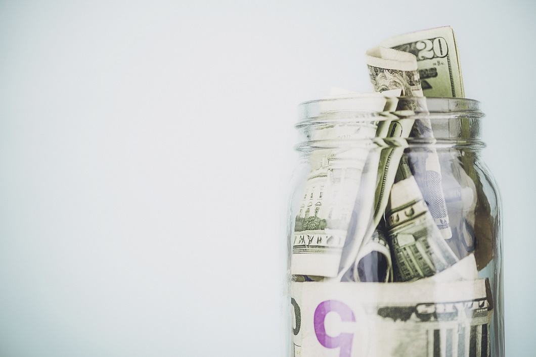 A jar overflowing with U.S. currency.