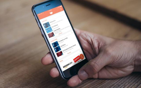 A man holding an iPhone with the Wallaby app open.