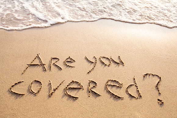 "Are you covered?" carved into the sand on the beach.