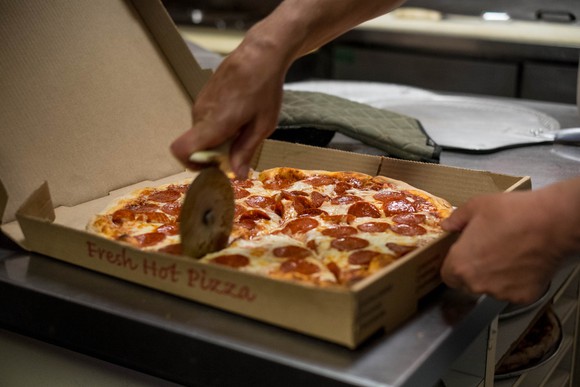 Pizza being cut up with a pizza cutter