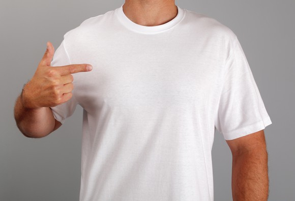 Man wearing white t-shirt pointing at himself.