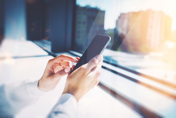 Person touching the screen of their smartphone.
