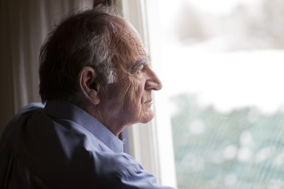 Sad senior man looking out the window