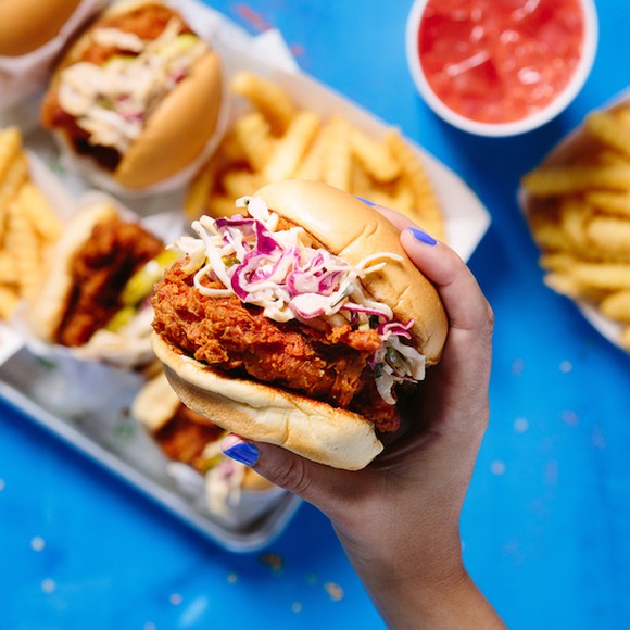 A woman holding Shake Shack's hot chicken sandwich