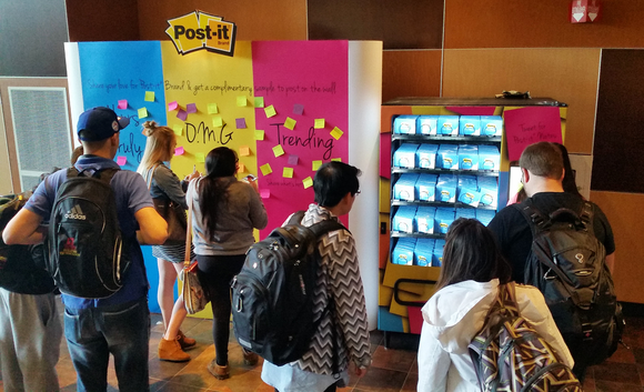 People in front of wall of Post-It Notes.