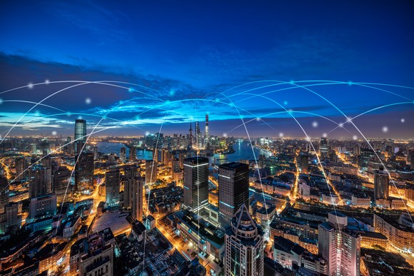 A city with white lines above it showing how everyone is digitally connected.