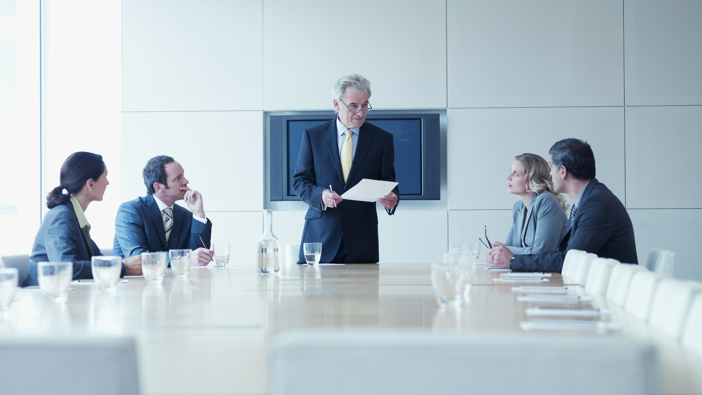 Business people sitting around a table in a conference room.