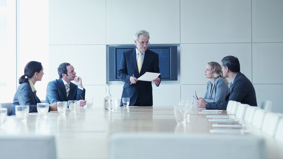 Business people sitting around a table in a conference room.