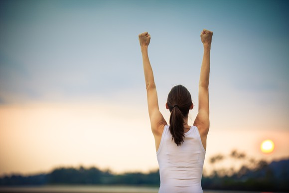 A woman raises her arms in triumph