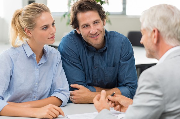 A financial advisor speaking with a younger couple.