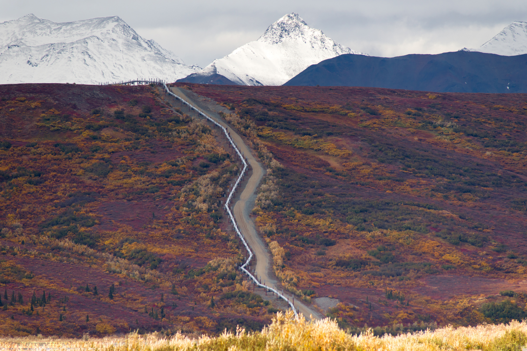 Oil pipeline cutting across a rugged mountain.