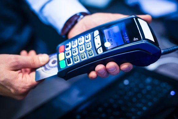 Man inserting a credit card into a credit card terminal.