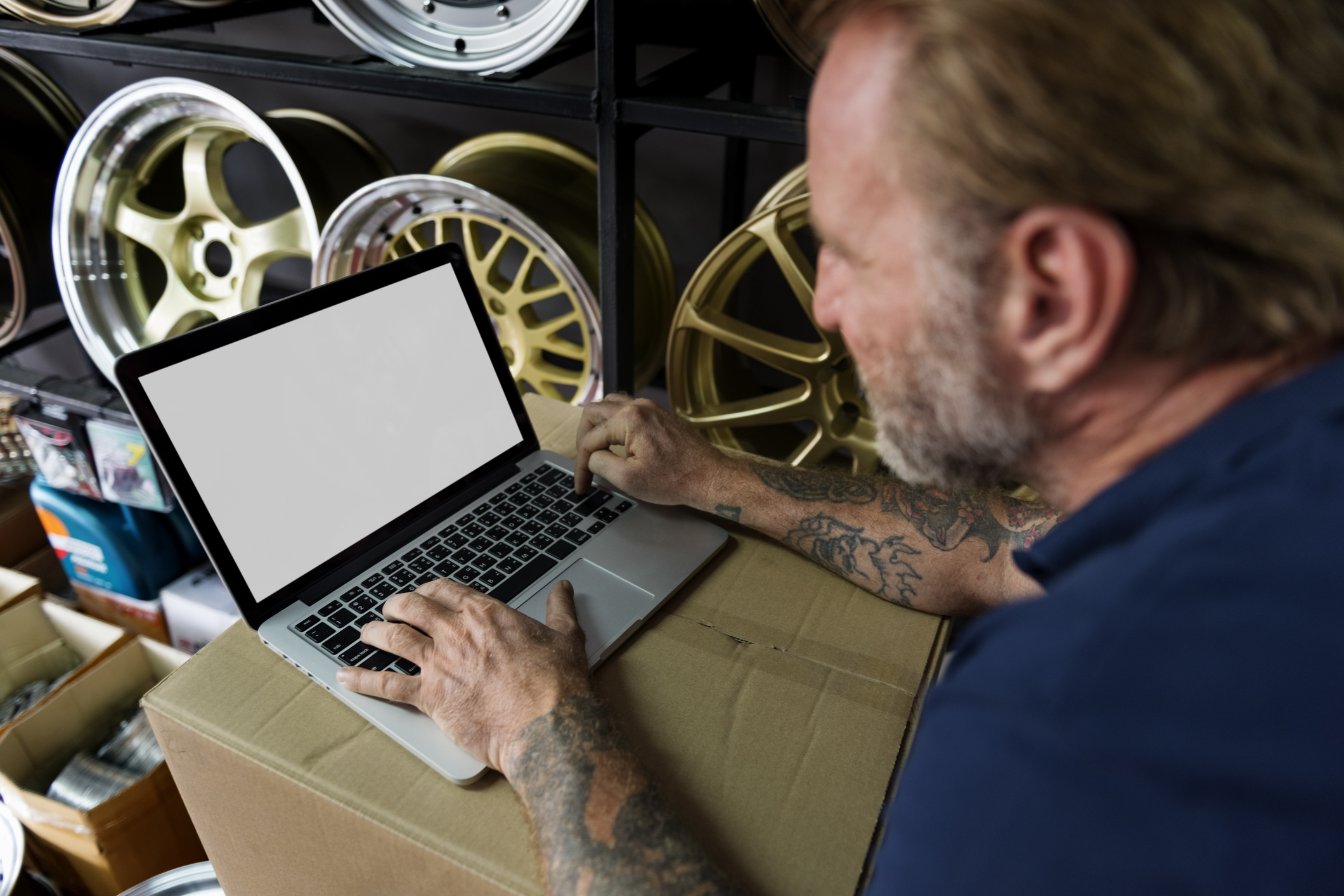 Auto retailer shop owner on a laptop