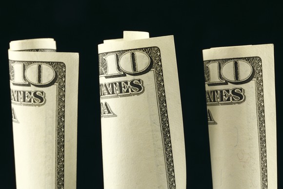 Three $10 bills rolled up