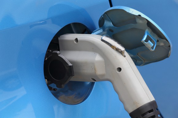 Close-up of a charging cord inserted into an electric vehicle.