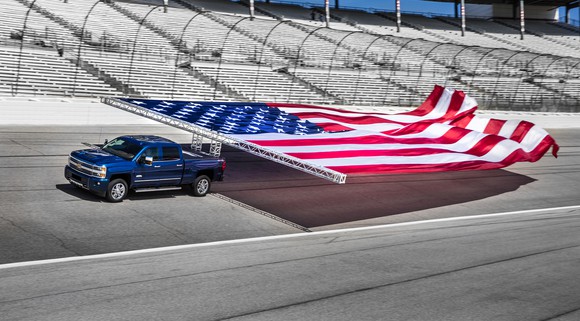 2017 Chevrolet Silverado towing a large American flag.