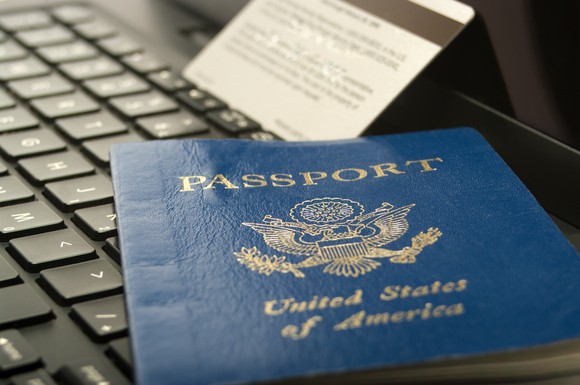 Close-up of a Passport laying on a laptop with a credit card in the background