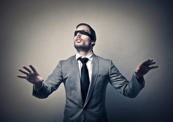 A blindfolded man in a suit