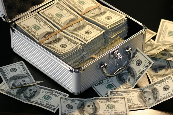 A silver suitcase with bundled $100 bills.