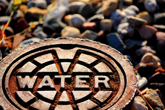 The word water spelled out on a metal cover