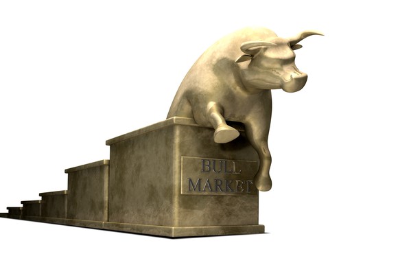 A golden bull climbing up a golden set of stairs. On the front of the stairs is a golden sign, reading "Bull Market."