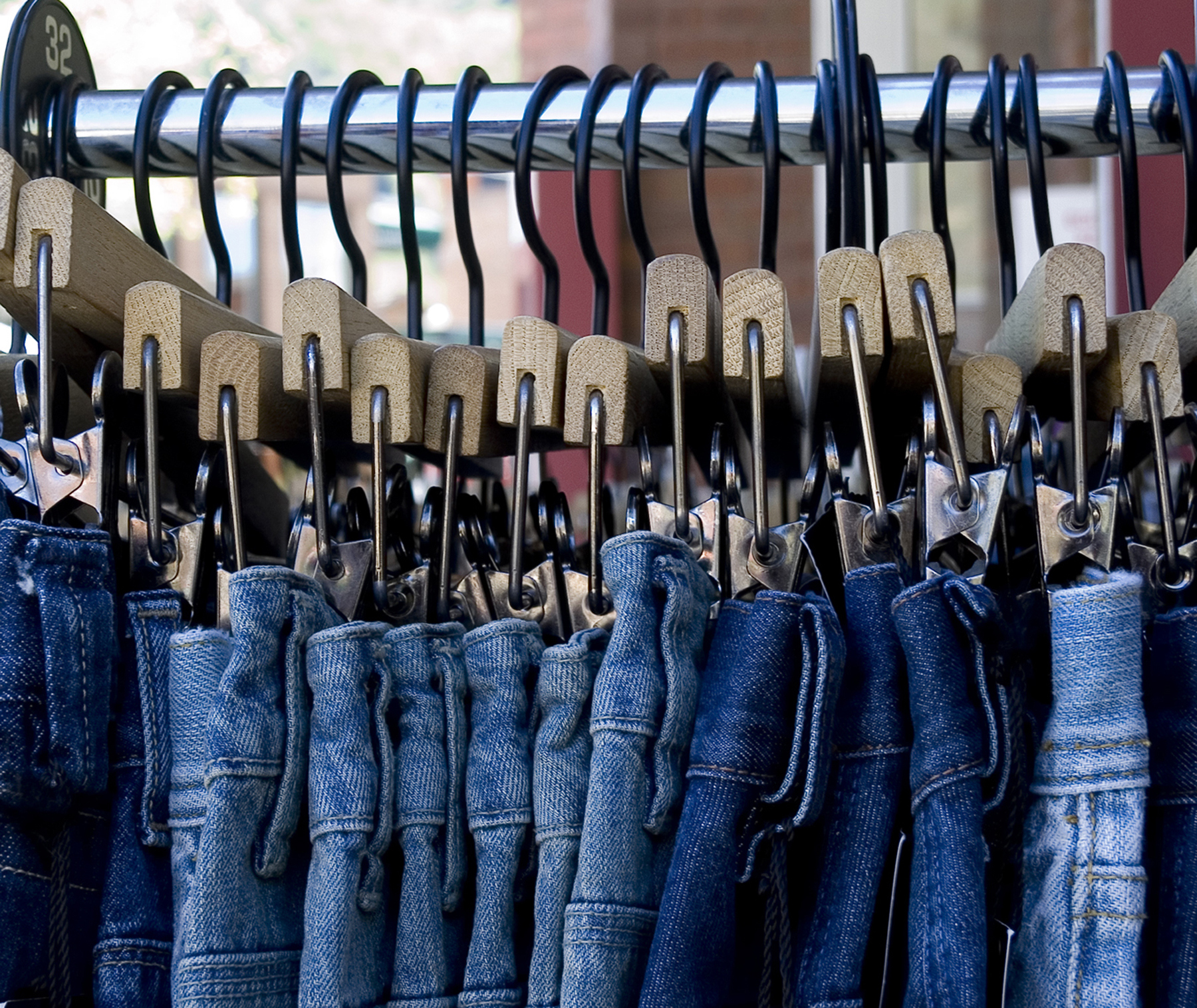 Blue jeans hanging neatly on a store rack