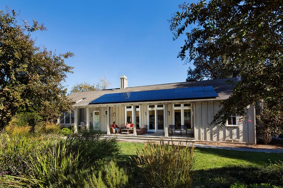 Rooftop solar system on a single level home with trees around the house.