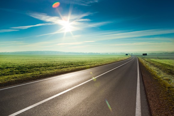 A long road stretches out into the distance.