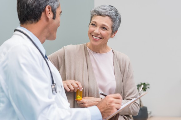 A senior woman discusses her prescription with her doctor.
