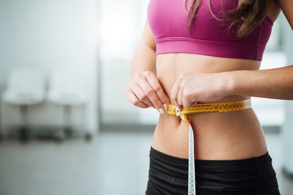 Woman measuring with a tape measure.