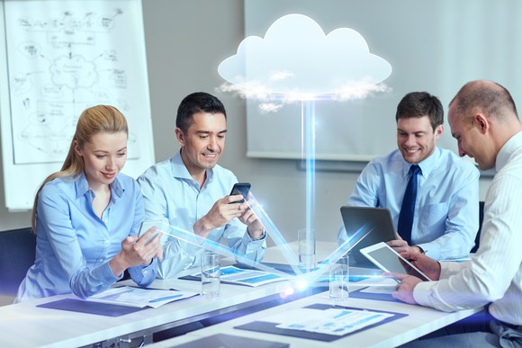 A group of business people gather data from the cloud.
