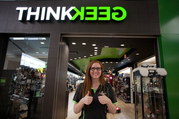 An employee gives a thumbs-up outside the grand opening of GameStop's ThinkGeek store in Tacoma, Washington.
