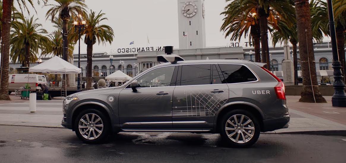 A Volvo SUV with Uber markings and self-driving sensor hardware visible is shown in San Francisco.