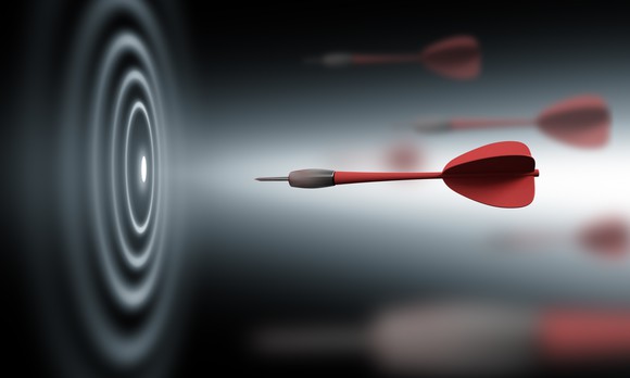 A red dart shooting toward a black and white bullseye