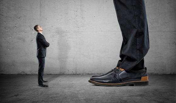 A businessperson looking up at a giant businessperson.