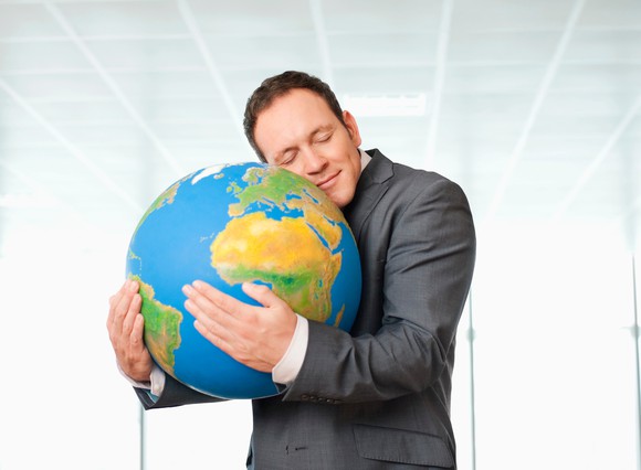 Man in suit embracing a globe.